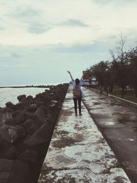 Rear view of man on sea against sky