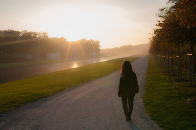 Rear view of man on road against sky during sunset