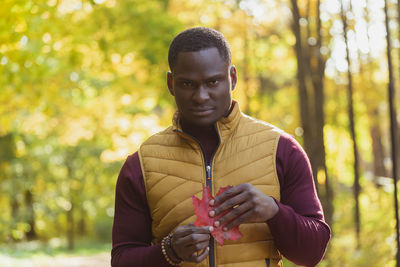 Portrait of young man holding plant