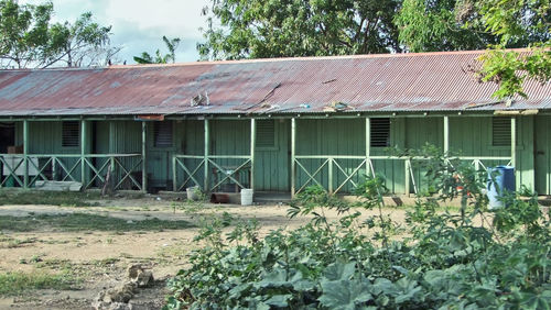 Exterior of abandoned house on field against sky