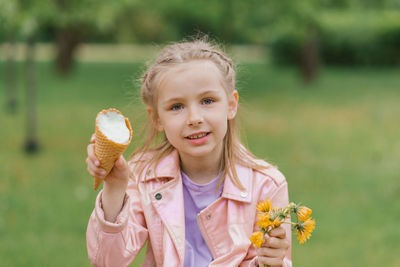 Child girl holds an ice cream cone in her hands in the spring in the park