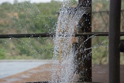 Close-up of water splashing on window during rainy season