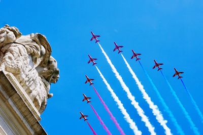 Low angle view of airplane flying against clear blue sky