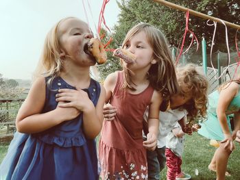 Young girls participating in a fun game of no-hands doughnut eating at a birthday party