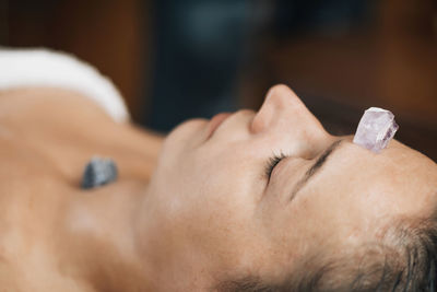 Ayurvedic practitioner using gemstones and crystals for healing female patient chakras