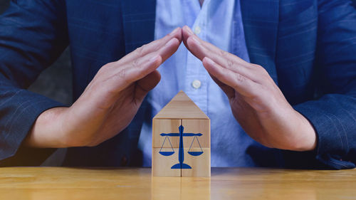 Midsection of man holding toy blocks on table