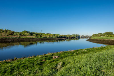 Scenic view of lake against clear blue sky