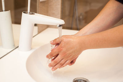 Midsection of woman in bathroom at home