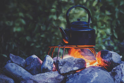Adventure cooking during camping metal kettle boiling on a campfire, surrounded by stones