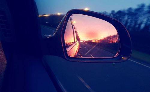 Reflection of man on side-view mirror