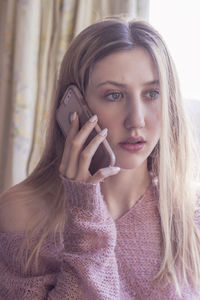 Young woman talking on the phone looks worried, distraught