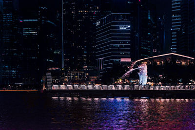 Illuminated buildings and marina bay sands at night