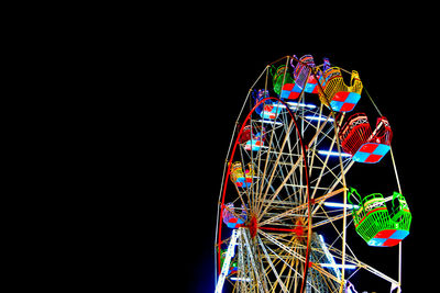Low angle view of illuminated ferris wheel against sky at night