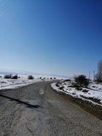 Scenic view of road against clear sky during winter