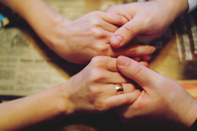 Cropped image of couple holding hands on table