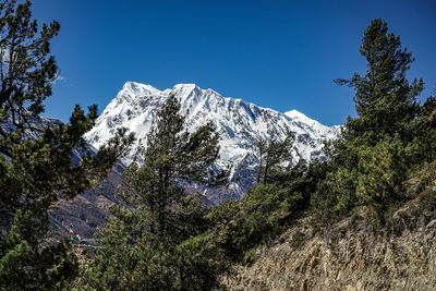 Low angle view of snowcapped mountains against clear sky