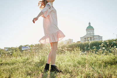 Woman standing on field against clear sky