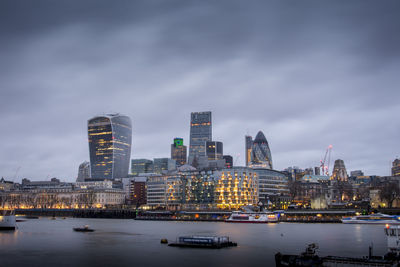 High angle view of thames river against modern buildings at dusk