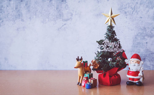 People with toys on table against christmas tree