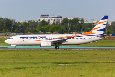 Side view of airplane on runway against sky