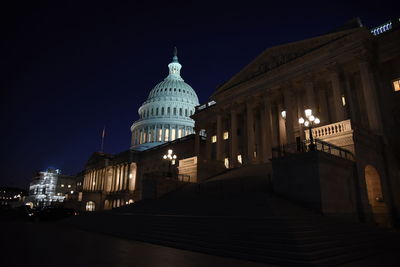 Low angle view of illuminated building against sky at night