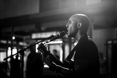 Side view of a young man playing guitar