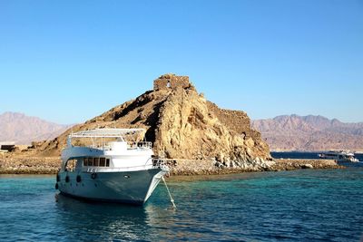 Sailboat on sea against clear blue sky