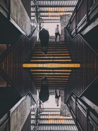 Rear view of people walking on staircase