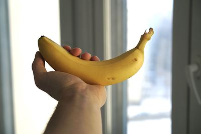 Personal perspective of hand holding banana