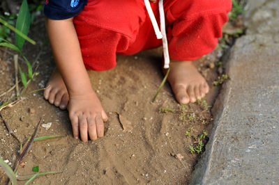 A small child is playing in the sand in the yard