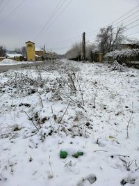 Snow covered land on field against sky