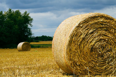 Hay bales on field against sky