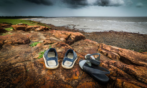 High angle view of shoes on beach against sky