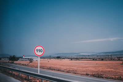 Road sign against sky