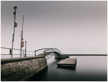 Bridge over sea against clear sky