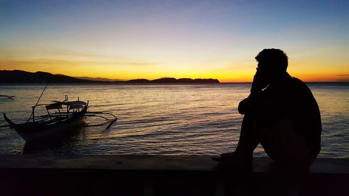 Silhouette of man looking at sunset