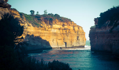 Rock formations by sea against sky