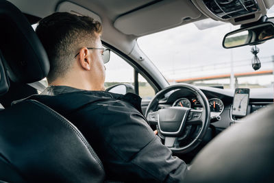 Rear view of man driving car