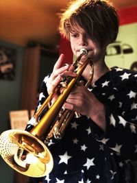 Boy looking away while playing musical instrument