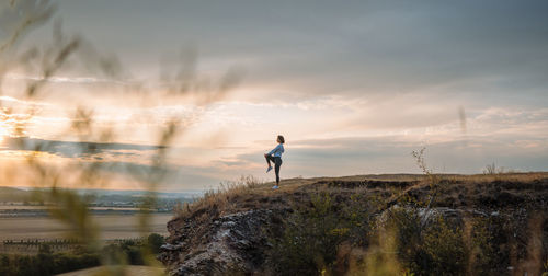 Yoga session on a hill at sunset, finding balance and serenity in the outdoor escape