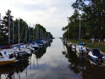 Boats moored in lake against sky