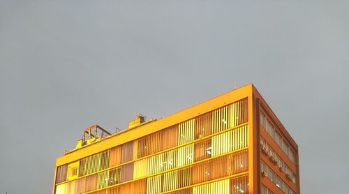 Low angle view of yellow building against sky