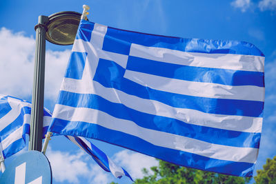 Low angle view of flags against blue sky