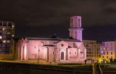 Illuminated building against sky at night