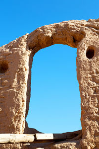 Low angle view of old ruins against clear blue sky