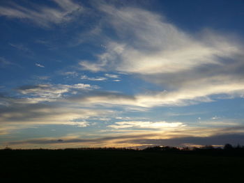 Scenic view of silhouette field against sky at sunset