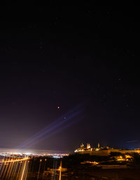 Illuminated city against sky at night