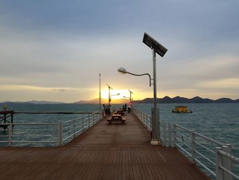 Pier over sea against sky during sunset