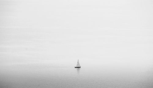 Sailboat sailing on sea against sky