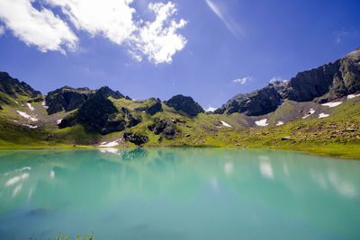 Alpine mountain lake at the daytime, sunlight and colorful landscape of golden water lake in svaneti